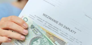 Zbliżenie na dłoń trzymającą banknoty leżące na dokumencie „Wezwanie do zapłaty” jako symbol agresywnej windykacji telefonicznej i listownej