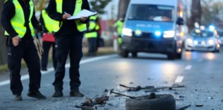 Policjanci zabezpieczający miejsce kolizji drogowej wśród rozrzuconych części auta jako symbol działań potrzebnych do ochrony swoich interesów po wypadku